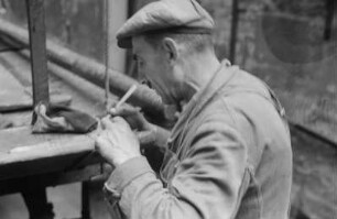 Reportage: Berliner Männer und Frauen tragen sich für die Ächtung der Atombomben ein : Arbeiter trägt sich in die Unterschriftenliste ein