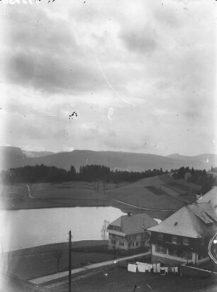 Blick aus einem Fenster auf eine Hügellandschaft mit See