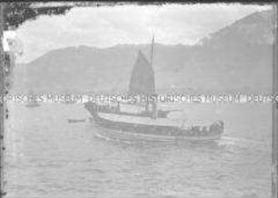 Kleines Passagierboot mit Schornstein in einer Bucht, Ostasien