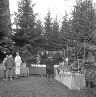 Rethwischdorf: Grundstück des stellvertretenden Kreispräsidenten Ernst Eick: Weihnachtsmarkt: vorn Marktstände mit Besuchern: dahinter Tannenreihe: im Hintergrund links Turm der Christuskirche