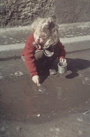 Ziegenrück. Spielendes Kind mit Aluminiumtöpfchen