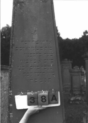 Grabstein 38 (Index: 99609674) Material: Sandstein Zustand: verwittert Maße HxBxT: 257x64x41 cm Beschreibung: Obelisk, Schriftfeld erhaben, Sims, getreppter Sockel: Grabstein 38A