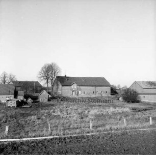 Bauerngehöfte auf Hügel: davor Weiden mit Zäunen