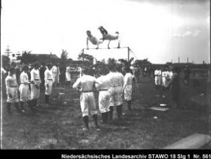 Turnfest der Turnvereine in Wolfenbüttel Enthält: Zwei Turner am Reck, Zuschauer