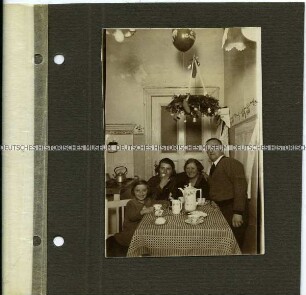 Familie beim Kaffeetrinken unter einem Adventskranz