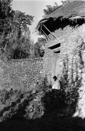 Bei Gonder : Ein Mann sitzt vor dem Eingang eines Bruchsteinhauses in der Nähe von Gonder.