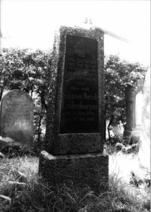 Grabstein 39 (Index: 100100556) Material: Granit mit geschliffener Platte Zustand: gut Maße HxBxT: 160x50x22 cm Beschreibung: Obelisk, Sockel Steinmetz: Pisot: Grabstein 39