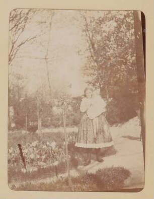 Franz von Hofmannsthal als Baby auf dem Arm einer Frau in Tracht im Garten