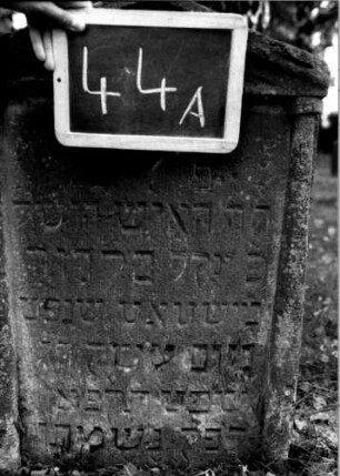 Grabstein 44 (Index: 100111094) Material: Sandstein Zustand: leicht verwittert Maße HxBxT: 77x52x11 cm Beschreibung: ädikulaartige Stele mit Halbsäulen, Giebel Symbolik: Herz, Blüte: Grabstein 44A