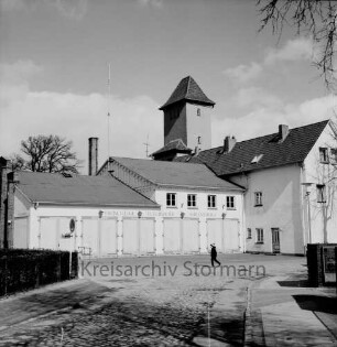 Feuerwache Woldenhorn: Schäferweg: [ehemaliges Elektrizitätswerk]: Feuerwehrgerätehaus mit Funkantenne: rechts Verwaltungsgebäude: dahinter Schlauchturm: davor Junge auf Einfahrt, links Hinweisschild "Stadtverwaltung"