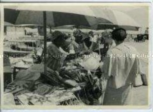 Touristinnen beim Kauf eines Hutes auf einem Markt in Nassau