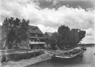 Schnackenburg : Schnackenburg. Wohnhäuser am linken Elbufer, ankernde Lastkähne in einem Hafenbecken. Blick nach Norden
