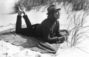 Das Model Helga Heitmann liegt auf einer Decke in den Dünen am Strand von Sylt