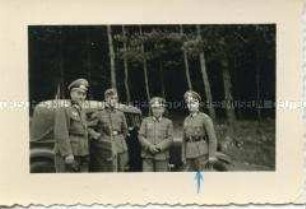 Vier im Offizierslager IX A Spangenberg stationierte Offiziere der Wehrmacht neben einem Auto