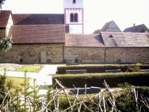 Ansicht von Norden mit Kirche (spätromanisch-frühgotisch) über Kirchhofmauer (Wehrgang im 18 abgetragen und einstige Pultdächer der Gaden durch Satteldächer ersetzt)