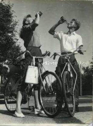 Zwei Fahrradfahrer machen Pause und trinken Limonade