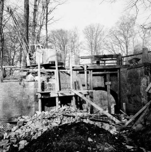 Brücke des Mühlenredder über dem Abfluss des Schlossgrabens: Renovierung: Seitenansicht von Süden: kein Durchfluss: Gerüst, Bauschutt: oben Baukran, Schubkarre