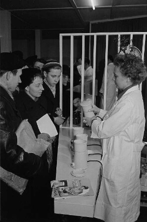 Messebesucher bei einer Vorführung von Kaffeemühlen im Ausstellungspavillon des VEM Sachsenwerk