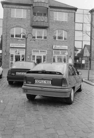 Vorstellung des Opel Kadett GSi 16 V: Rückansicht mit Spoiler auf Heckklappe: auf Parkplatz Hagener Allee, Ahrensburg: hinten Geschäfte paperdreams, Pinocchio