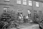 SPD: Alte Schule: Besichtigung: Kreistagsabgeordneter Rüdiger Hildebrandt und Stadtverordnete Gerd Herrmann, Rolf-Jürgen Hanf und Heinz Hartmann mit Unterlagen auf Treppe vor Eingang: links Fahrräder und Busch: rechts Pkw und Blumen