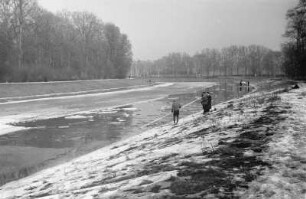 Zugefrorener Elsterflusslauf : Zwei Männer mit einer Stange beim Abfischen von durch Eissprengungen getöteten Fischen am zugefrorenen Elsterflusslauf.