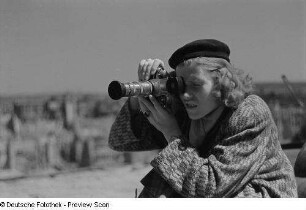 Renate Rössing mit beim Fotografieren vor Gebäudetrümmern