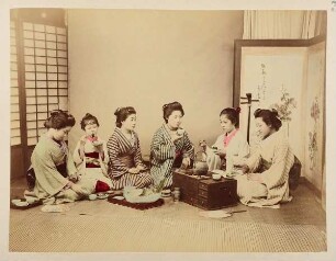 Sechs japanische Frauen essend und Tee trinkend