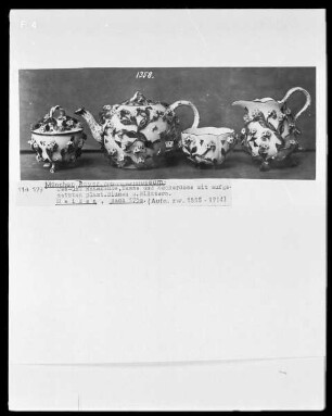 Tee- und Rahmkanne, Tasse und Zuckerdose mit aufgesetzten plastischen Blumen und Blättern