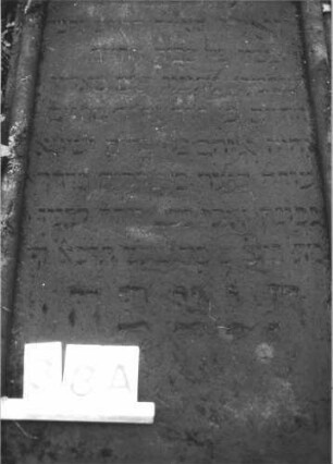 Grabstein 38 (Index: 100105997) Material: Sandstein Zustand: Stein liegend, stark verwittert Maße HxBxT: 133x62x18 cm Beschreibung: Stele von Halbsäulen umfaßt, eingezogener Rundbogenabschluß mit Eckakroteren, rechteckiges Schriftfeld eingetieft Symbolik: Zahnschnittfries: Grabstein 38A