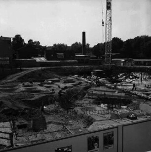 Kreissparkasse Stormarn: Hagenstraße: Blick auf Baustelle mit Fundamentarbeiten: dazwischen Arbeiter: hinten rechts Baukran: dahinter Gewerbegebäude und Schuppen: vorn Bauzaun mit Plakaten der Sparkasse: hinten rechts Bäume des Bürgerparks