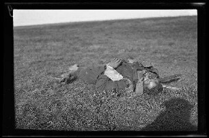 Nicht identifizierbare Gegend in Nordfrankreich oder Belgien: gefallener Soldat auf einem Feld (Vorderansicht) ("Gefallene")