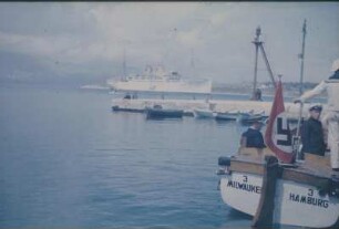 Reisefotos. Das Passagierschiff "Milwaukee" vor einer Küste. Ansicht mit Passagieren im Beiboot beim Übersetzen zum Landgang