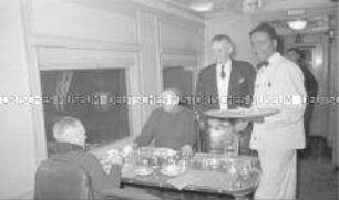 Selbstversenkung des Hochseepassagierdampfers "Columbus" am 19. Dezember 1939, Überführung von Besatzungsangehörigen vom Internierungslager auf Ellis Island in das Internierungslager auf Angel Island, Kalifornien, zwei Männer und Servicepersonal während einer Mahlzeit im Speisewagen