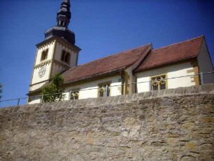 Evangelische Pfarrkirche-Ansicht von Südsüdosten mit Kirche (romanische Gründung mit Rechtecktor sowie Westturm) über Kirchhofmauer (Wehrgang im 19 Jh abgetragen)
