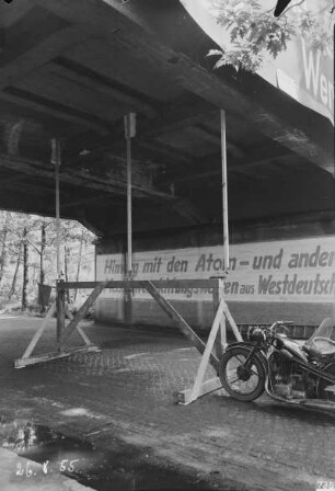 Eisenbahnbrücke der Grubenbahn zum Industrie-Kraftwerk Lauta über eine Dorfstraße. Untersicht auf Holzgerüst mit Meßstellen für das (Durchbiegungs-?)Verhalten des Brückenüberbaues; am Widerlager Losung "Hinweg mit den Atom- und Massenvernichtungswaffen aus Westdeutschland" : Laubusch (Niederlausitz). Eisenbahnbrücke der Grubenbahn zum Industrie-Kraftwerk Lauta über eine Dorfstraße. Untersicht auf Holzgerüst mit Meßstellen für das (Durchbiegungs-?)Verhalten des Brückenüberbaues; am Widerlager Losung "Hinweg mit den Atom- und Massenvernichtungswaffen aus Westdeutschland"