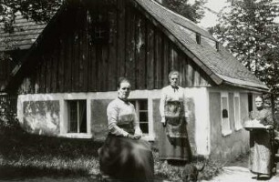 Giersdorf / Podgórzyn. Wohnhaus : Giersdorf (Kreis Hirschberg) / Podgórzyn (pow. Jelenia Góra/Polen). Wohnhaus. Giebelansicht, davor drei Frauen in Festkleidung