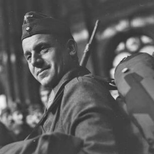 Wehrmachtssoldat mit Schiffchen und Gewehr, Soldaten auf Urlaub