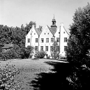 Kloster Nütschau: Herrenhaus: Südfront: vorn Rasenfläche: rechts und links Büsche und Bäume