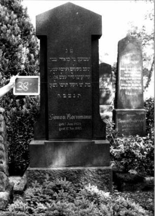 Grabstein 38 (Index: 100110022) Material: Granit Zustand: gut Maße HxBxT: 200x74x30 cm Beschreibung: Stele, getreppter Sockel, giebelartiger Abschluß Steinmetz: Ostberg: Grabstein 38