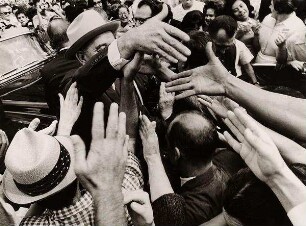Lyndon B. Johnson steht grüßend in der Menschenmenge