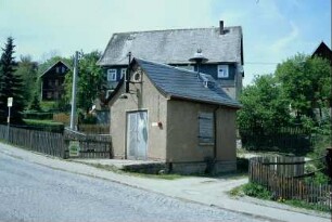 kleines Feuerwehrgerätehaus mit Sirene auf dem Dach
