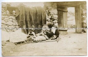 Frau mit zwei Kindern vor Mauer