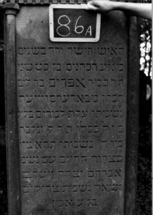 Grabstein 86 (Index: 100111179) Material: Sandstein Zustand: gut Maße HxBxT: 195x71x18 cm Beschreibung: ädikulaartige Stele mit Halbsäulen, giebelartiger Abschluß mit Verdachung Symbolik: segnende Hände, Zahnfries: Grabstein 86A