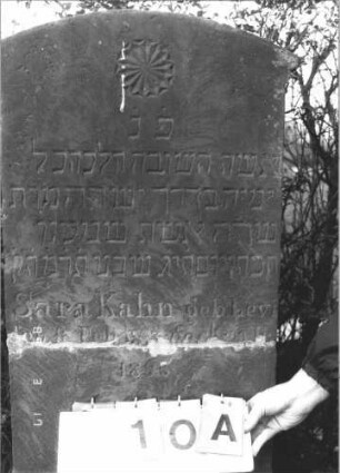 Grabstein 10 (Index: 99808573) Material: Sandstein Zustand: zerbrochen und repariert Maße HxBxT: 143x51x13 cm Beschreibung: Stele, getreppter Sockel, Segmentbogenabschluss mit Ohren Symbolik: vielzackiger Stern: Grabstein 10A