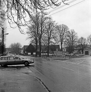 Möllner Landstraße: rechts Abzweigung Lauenburger Straße: in der Mitte Verkehrsschilder: dahinter Grünfläche mit Bäumen: dahinter "Schwarkes Gasthof"und weitere Gebäude: vorn links Abzweigung Granderheider Straße mit Pkw: dahinter weitere Pkws