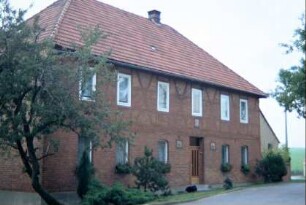 Backsteinbau mit großen Fenstern, in dem Steine vom alten Edelhof verbaut sind