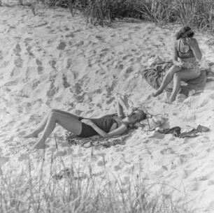 Zwei Frauen in Bademode liegen am Strand, rechts Elisabeth Gremmler