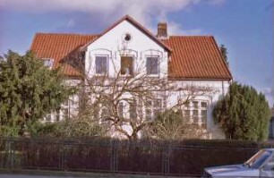 Bahnhofstraße 1: traufständiges Wohnhaus: Straßenfront mit Mittelrisalit, Eingangstür, Zwerchgiebel: Vorgarten: vorne Hecke, Garten, Gartenzaun mit Schmiedeeisen