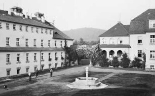 Coswig. Kreispflegeheim Wettinstift (1913, 1919-um 1935; E. Pönisch). Gartenansicht mit Brunnenanlage vor Erweiterungsbau mit Torbau und Hauptgebäude