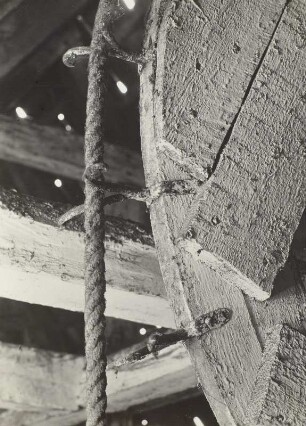 Stralsund: Aufzugsrad auf Boden eines Bürgerhauses. Detail: geschmiedete Gabeln auf den Felgen des Rades zum Führen des Zugseiles